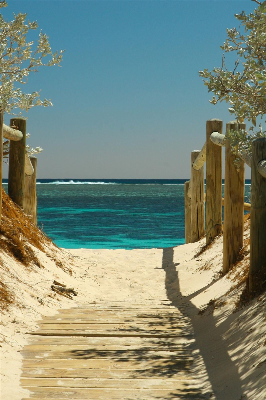 Wooden boardwalk leading to a sunny beach
